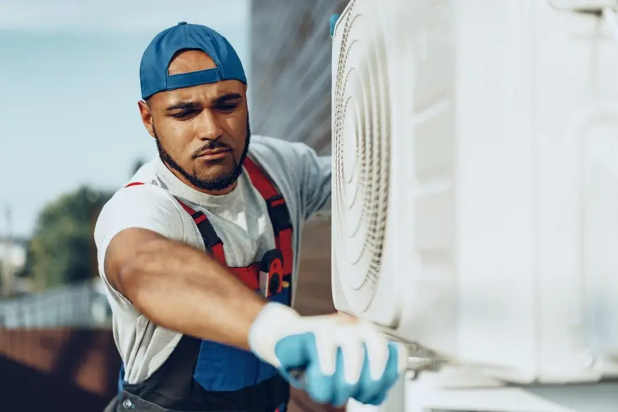 K Star technician checking an outdoor AC unit